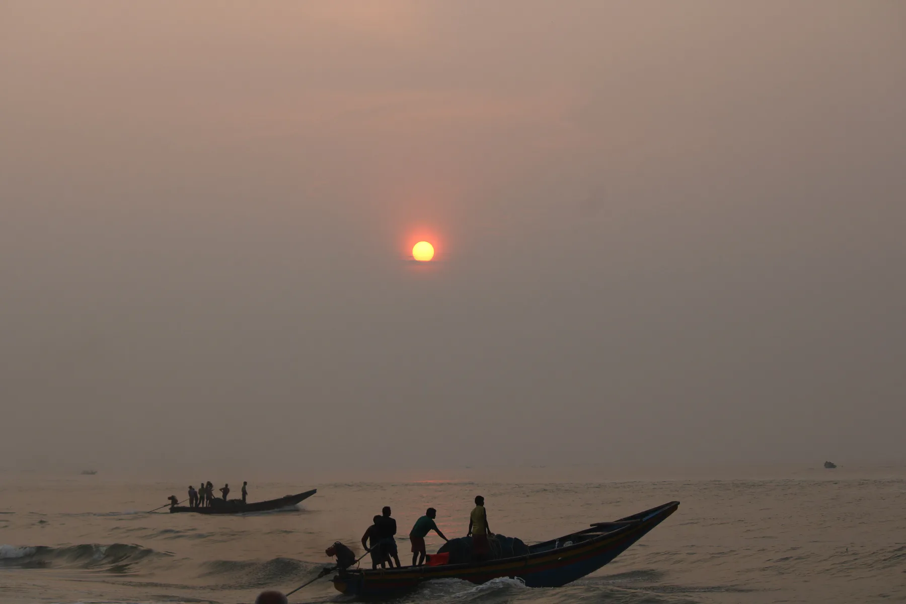 Rising sun and busy fishermen at Puri Beach